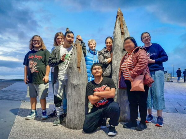 Group of people standing with 2 bollards, smiling at the camera