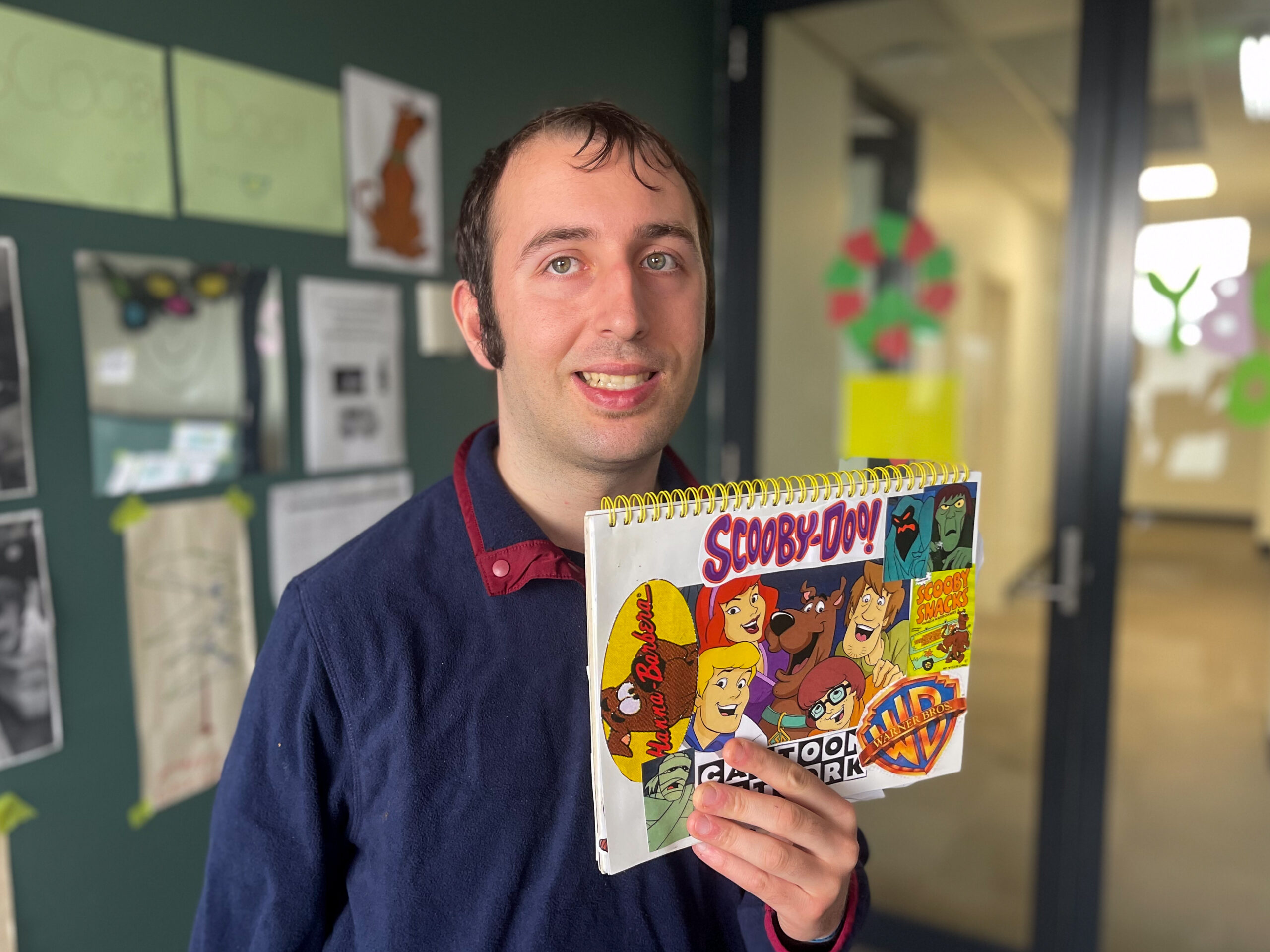 Young man from Social Connect holding his ABC book he created