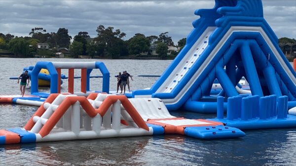 Participants and support workers play on water playground